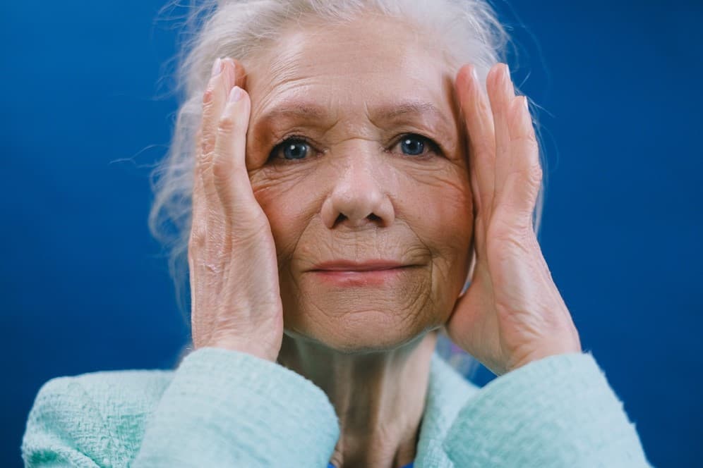 女性老人摀著頭,老年人失智風險女性