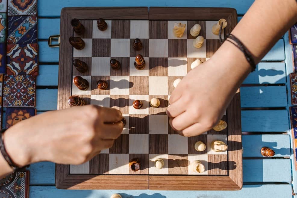 兩隻手正在下西洋棋，訓練大腦認知邏輯能力