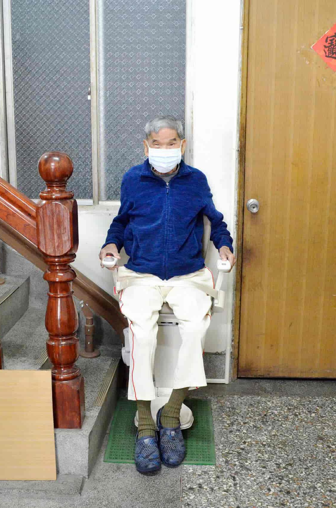 退休生活的長輩坐在泓電樓梯升降椅上並繫上安全帶