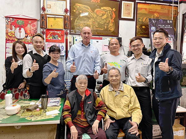 泓電業務人員與荷蘭原廠人員前往關心客戶的合照，客戶坐在前方升降椅~