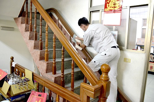 泓電樓梯升降椅的工程師正在樓梯上擦拭軌道